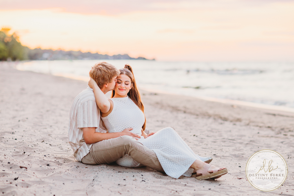 Durand Eastman Park in Irondequoit, NY, Couple poses for Engagement portrait photography session at sunset on the beach , portraits done by Destiny Burke Photography