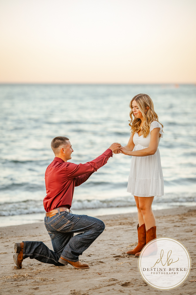 Surprise beach proposal at Durand Eastman Beach near Rochester, NY, captured by the best surprise proposal photographer near Rochester, NY during golden hour along Lake Ontario.