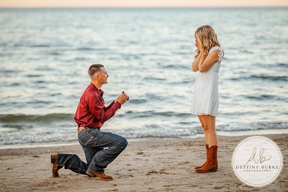 Surprise beach proposal at Durand Eastman Beach near Rochester, NY, captured by the best surprise proposal photographer near Rochester, NY during golden hour along Lake Ontario.