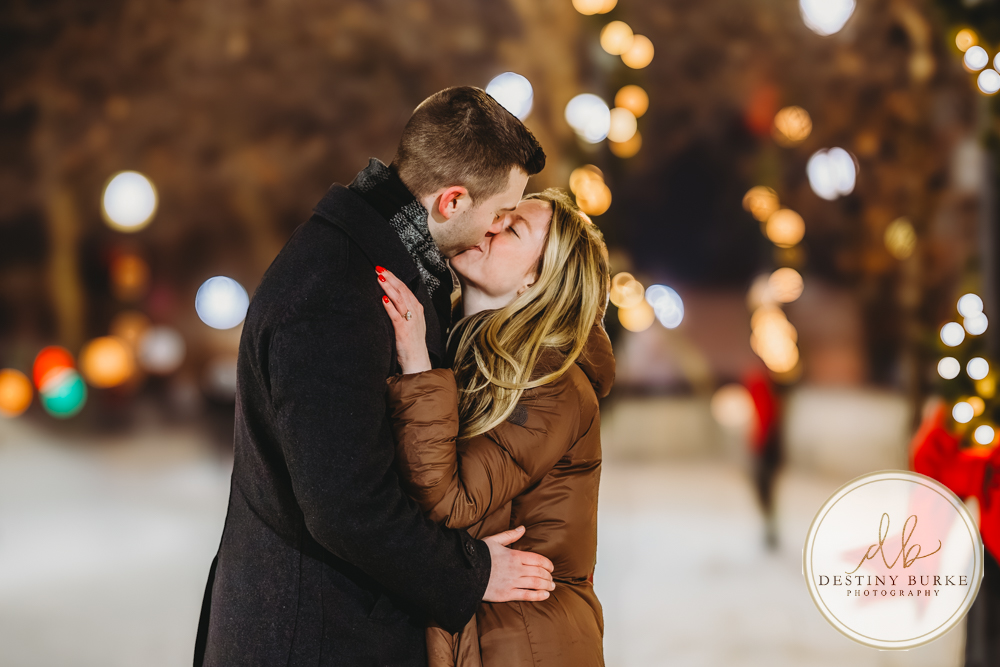 Discreetly photographed surprise proposal at the Liberty Pole in Rochester, NY designed for clients seeking a seamless, stress-free luxury engagement experience.