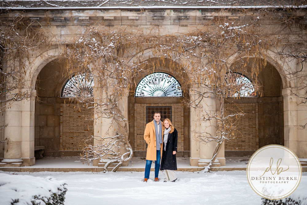 Newly engaged couple holding hands showing ring at George Eastman Museum in Rochester NY