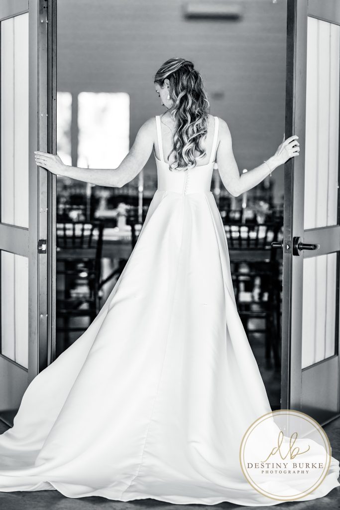 Bride opening reception doors before wedding ceremony at Pomona at Blue Barn Hilton NY