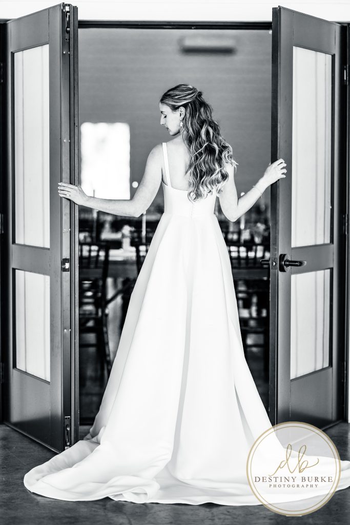 Bride opening reception doors before wedding ceremony at Pomona at Blue Barn Hilton NY